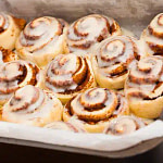 cinnamon buns with icing on a white plate