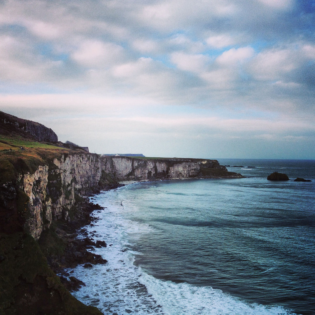 a view of the cliffs and ocean on a cloudy day