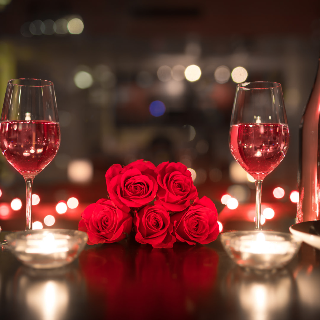 Valentine's day table setting with red roses and wine glasses