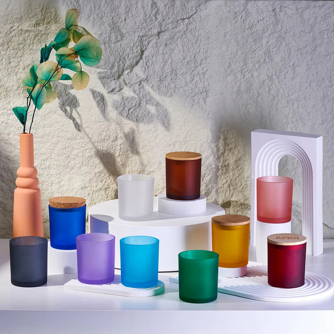 various colored candles sit on a shelf next to a vase