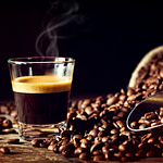 coffee beans and a glass of espresso on a wooden table