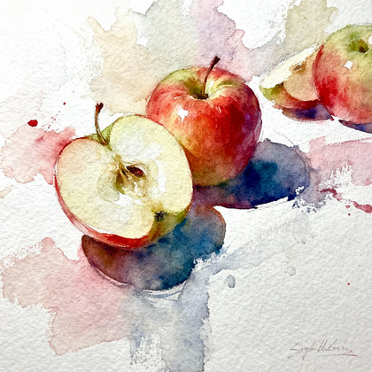 A complete red apple beside a half one