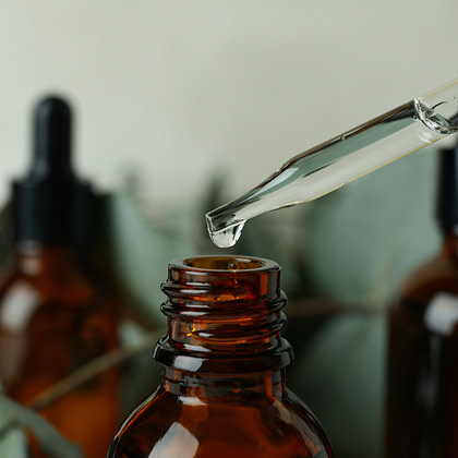 a bottle of essential oil is being poured into a bottle