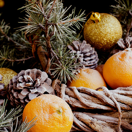 oranges and pine cones in a basket on a table