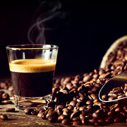 coffee beans and a glass of espresso on a wooden table