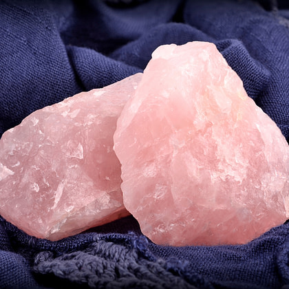two pink rocks sitting on top of a blue cloth
