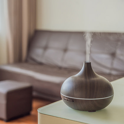 An aroma diffuser is sitting on a table in front of a couch