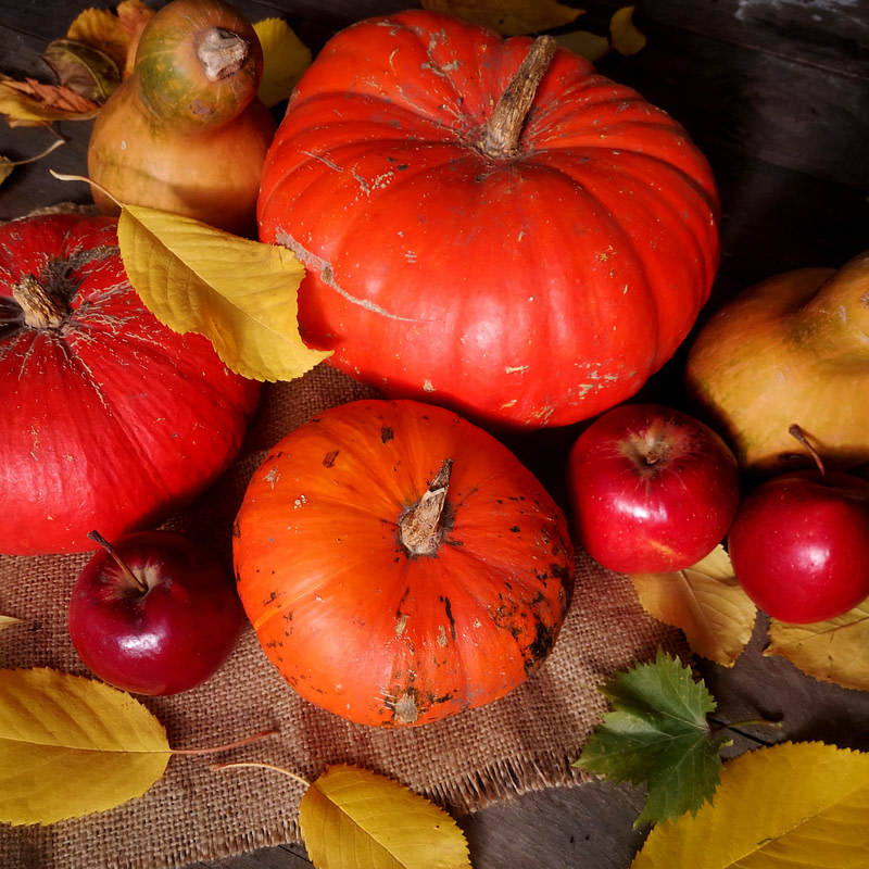 pumpkins, apples and leaves on a wooden table