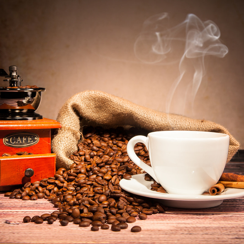 coffee beans and a coffee grinder on a wooden table