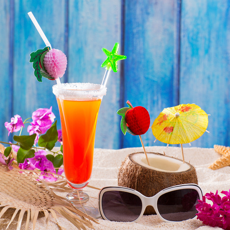 summer cocktails on the beach with straw hat and sunglasses