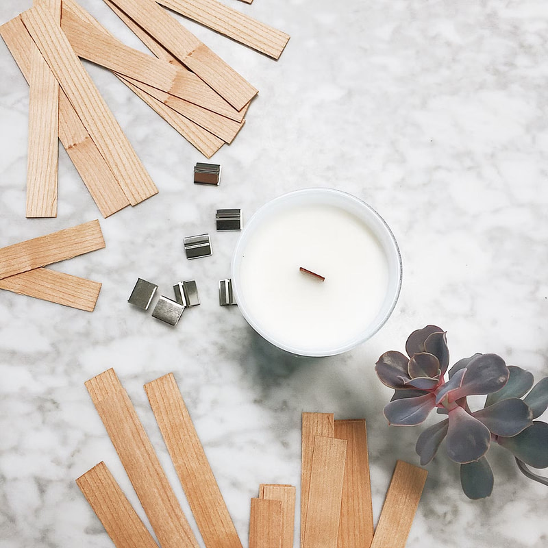 wooden sticks and a candle on a marble counter