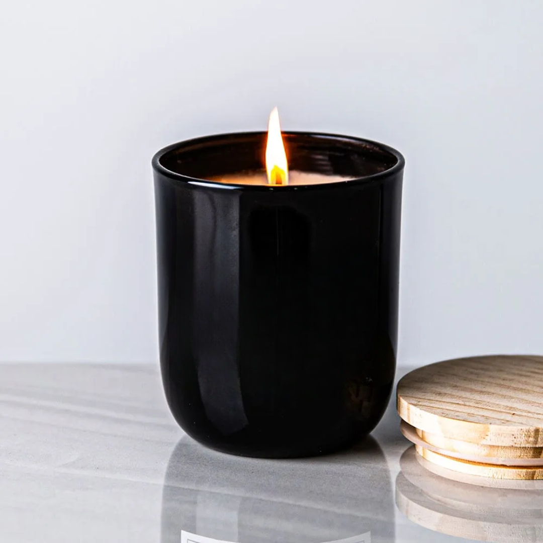 a candle sits next to a wooden coaster