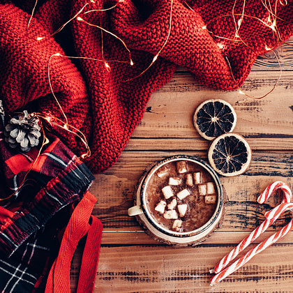 hot chocolate with marshmallows and candy canes on a wooden table