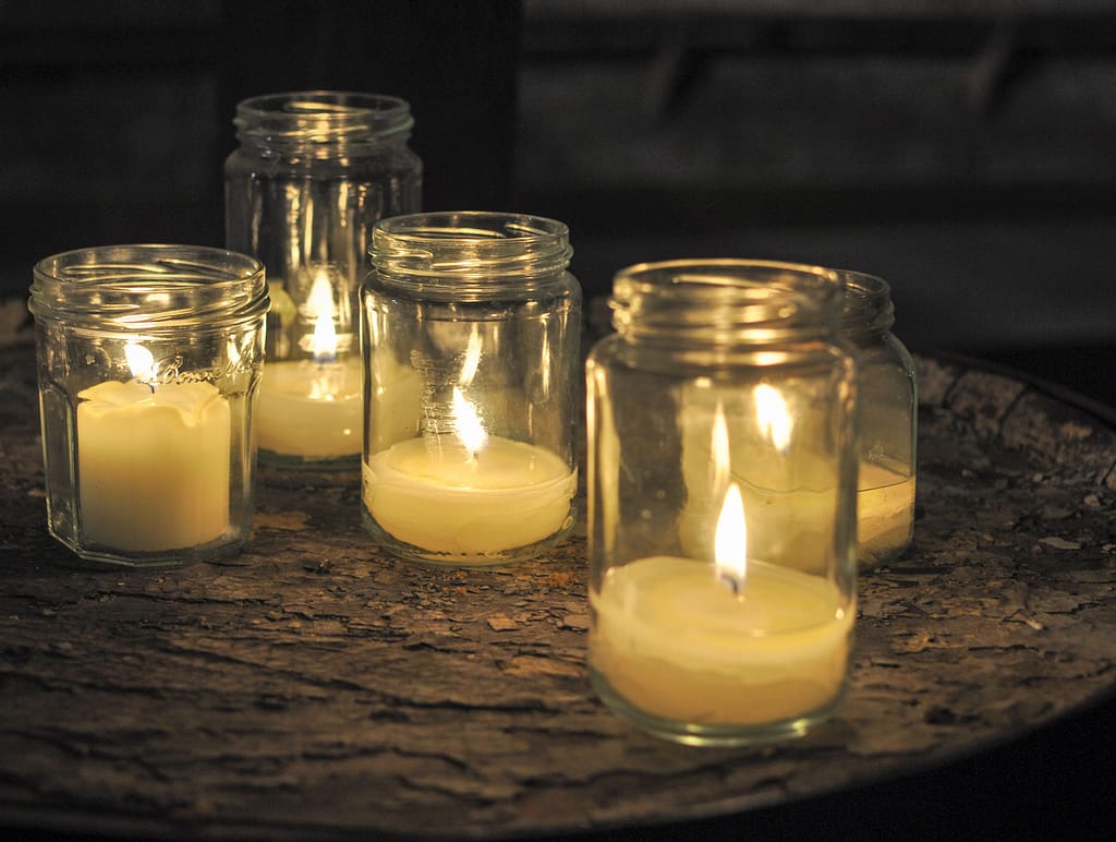 Candles burning in transparent jars and dark space